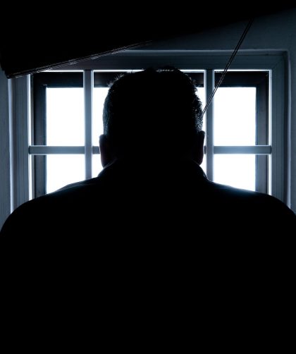 rear view of a silhouette man in window