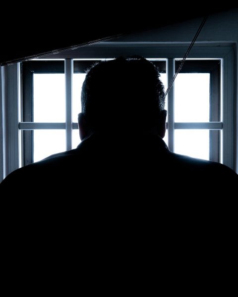 rear view of a silhouette man in window