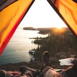 tourist lying in camping tent near shore