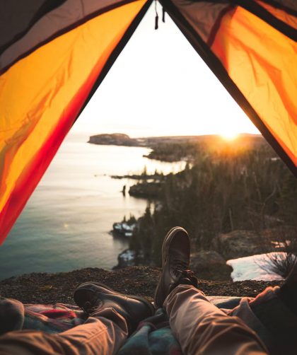 tourist lying in camping tent near shore