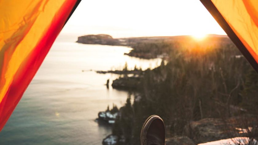 tourist lying in camping tent near shore