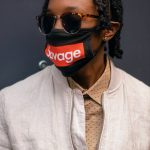 man wearing a beige jacket and facemask posing