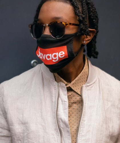 man wearing a beige jacket and facemask posing